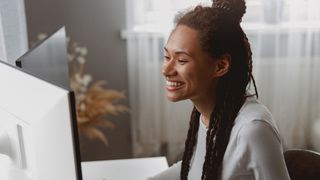 Smiling female worker at her remote workstation at home