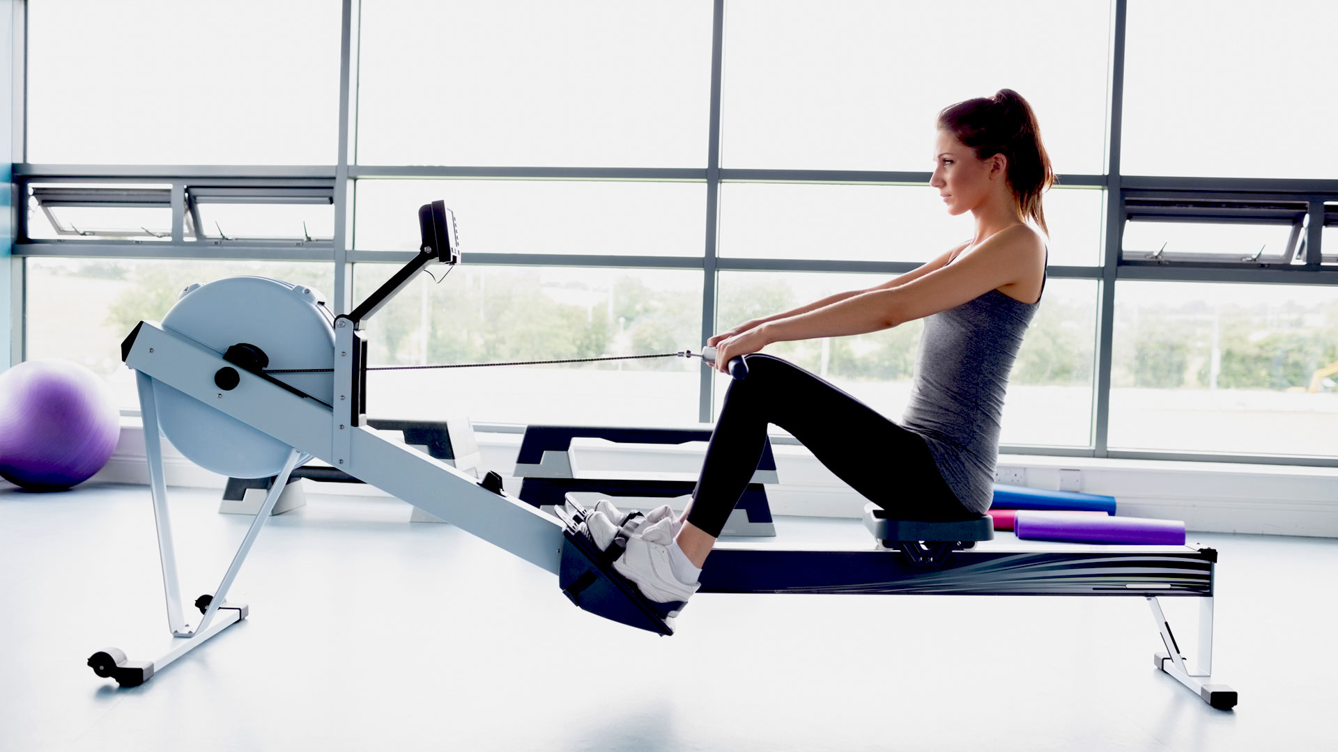 A woman uses a rowing machine