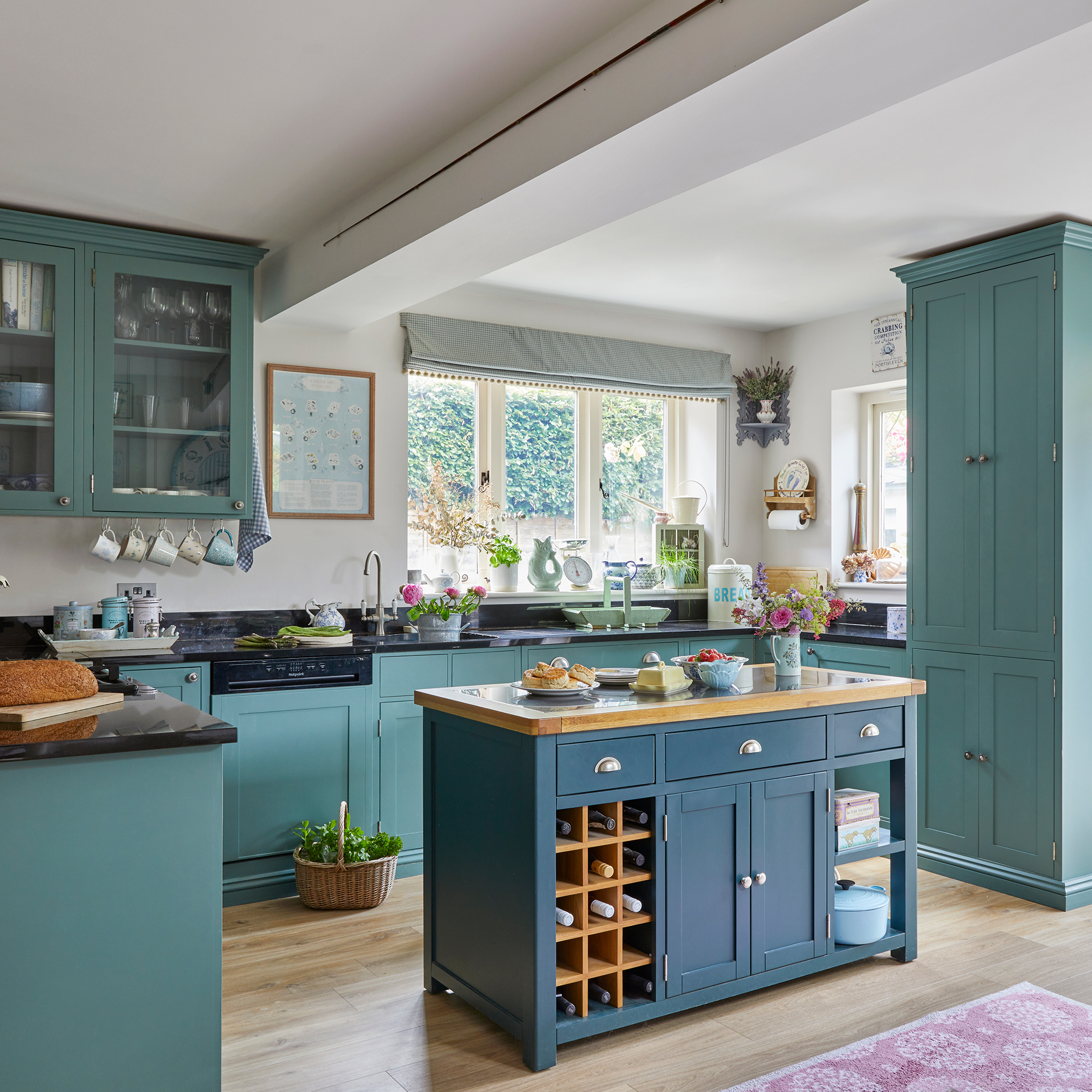 teal country style kitchen with mix of wall, floor and tall cabinets and a freestanding island unit