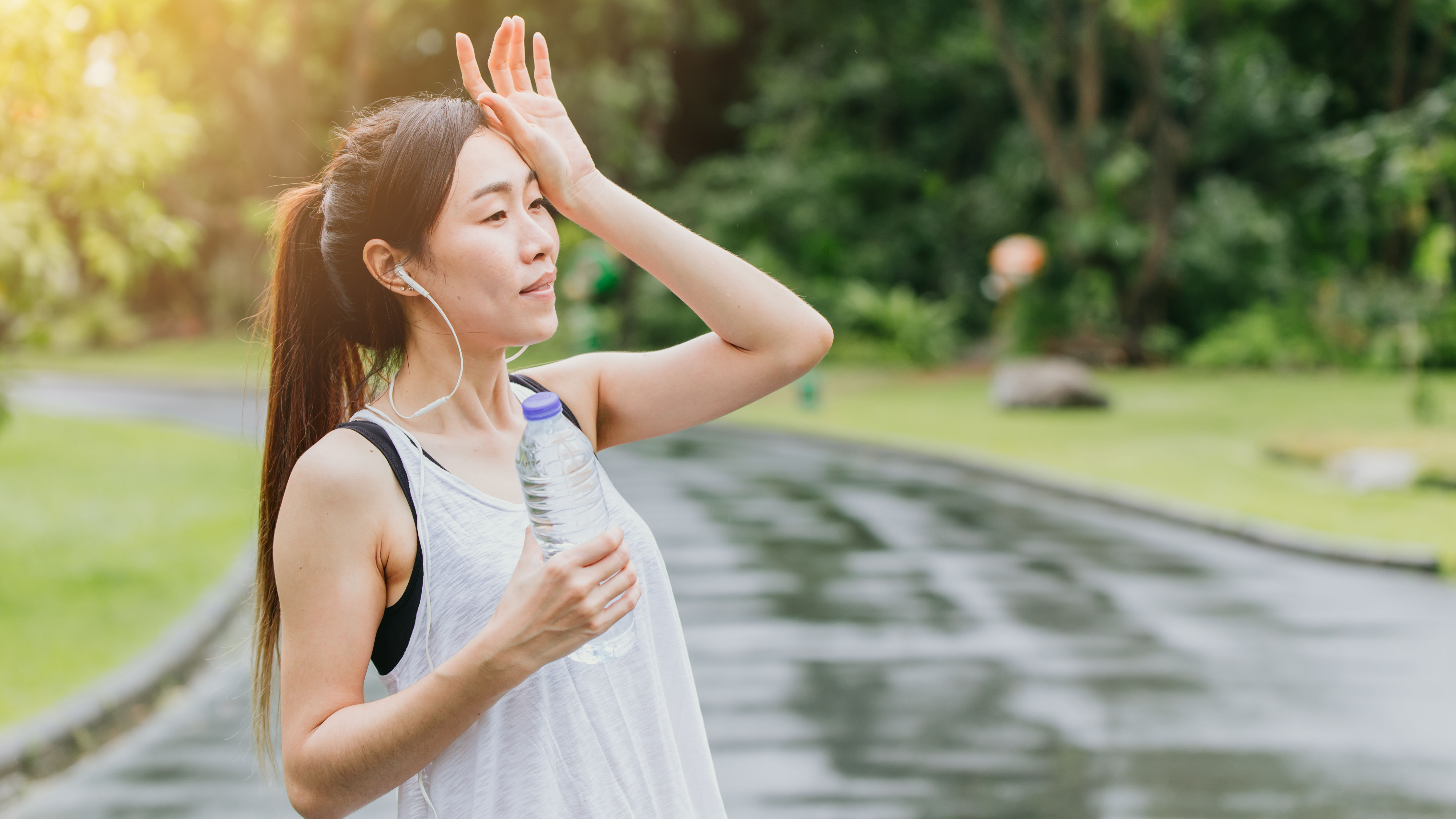 Woman pausing on run to drink water