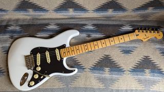 The Fender Player II Stratocaster in black and white on a patternedblue, black and white rug