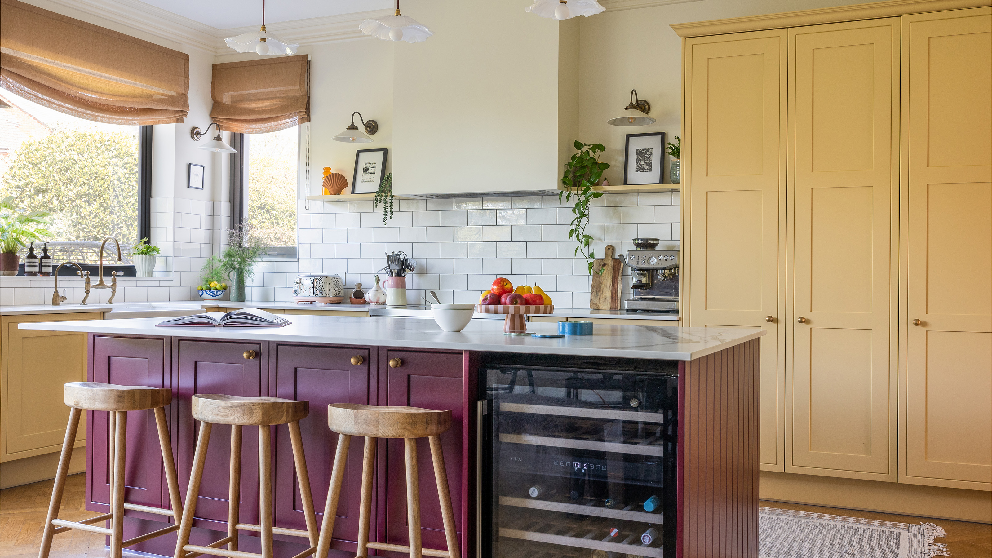 Yellow and burgundy kitchen with white metro tiles