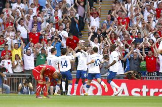 Ashley Young (centre) celebrates scoring for England (PA)
