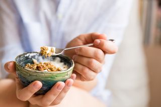 What is protein? A woman eats yoghurt and granola