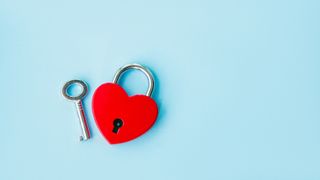 A heart shaped lock with key on a blue background.