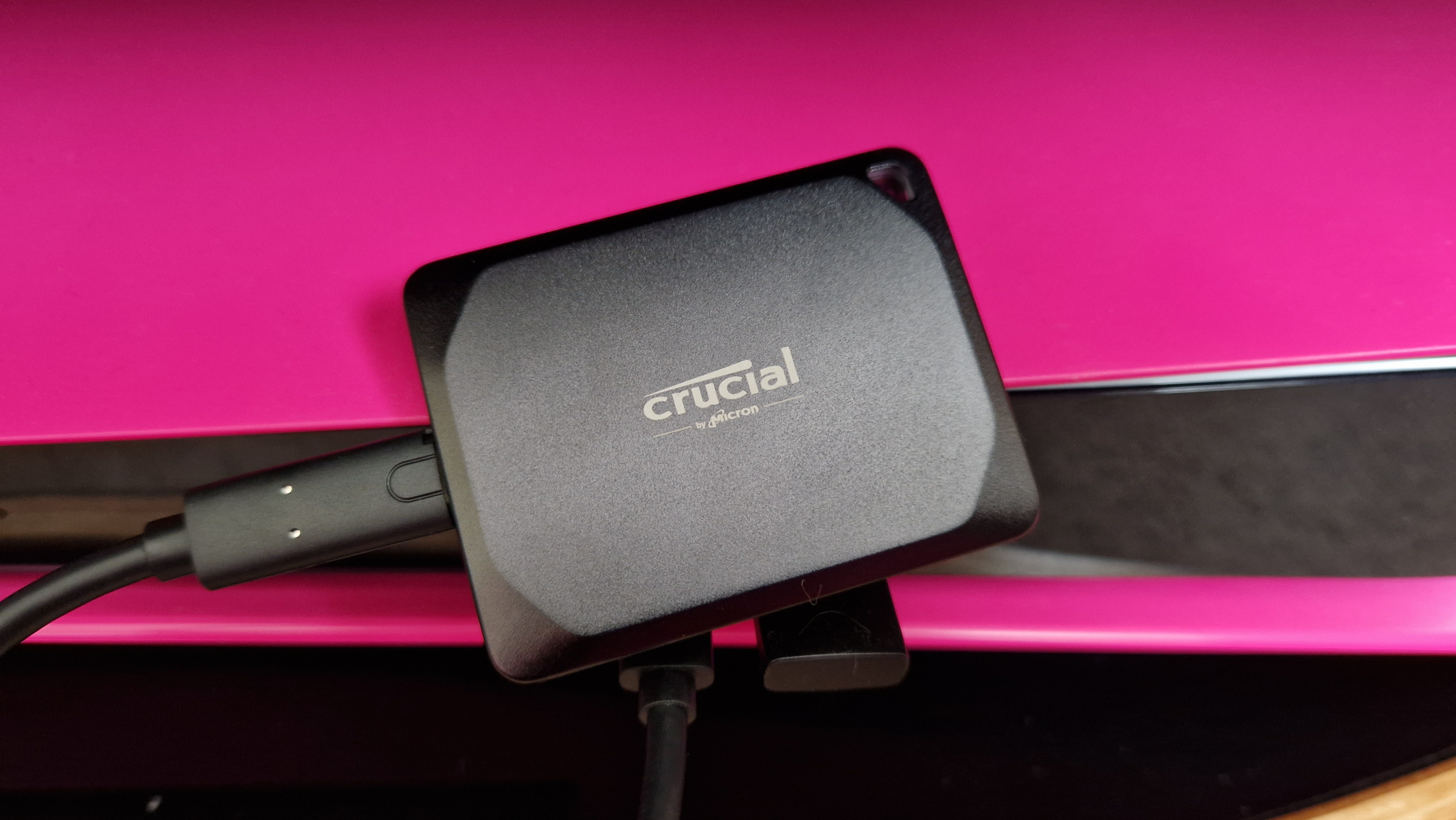 Crucial X10 Pro up close while sitting on a pink PS5