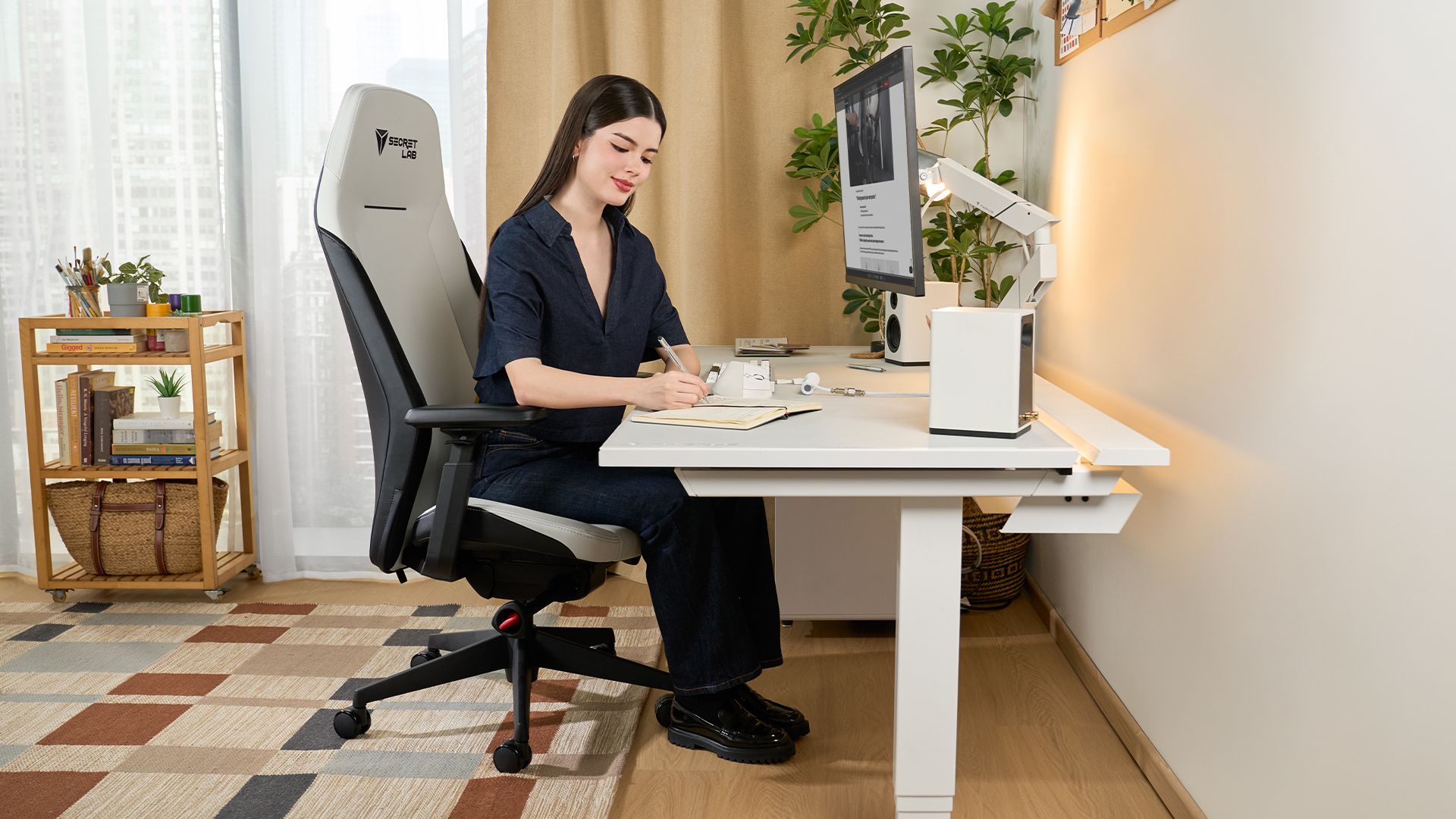 A marketing image of a woman sitting in the Secretlab Atlas