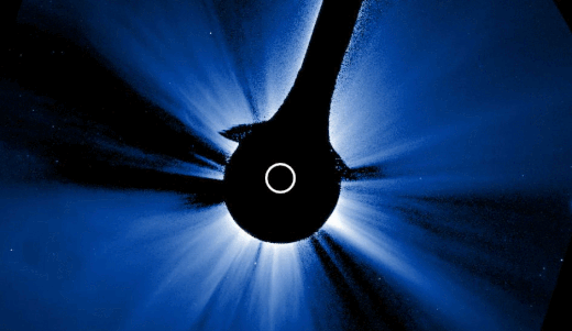 the moon passes from right to left across a black background on which a bright white and blue starburst pattern is spread