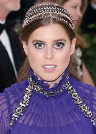 A headshot of Princess Beatrice shows her headband and jewelled detailing on her purple dress at the Met Gala 2018