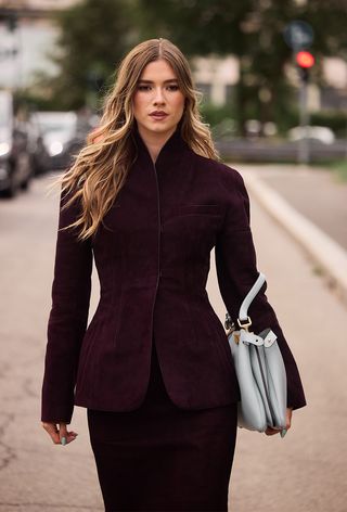 Milan Fashion Week spring 2025 street style photo of a woman wearing the wine red color trend