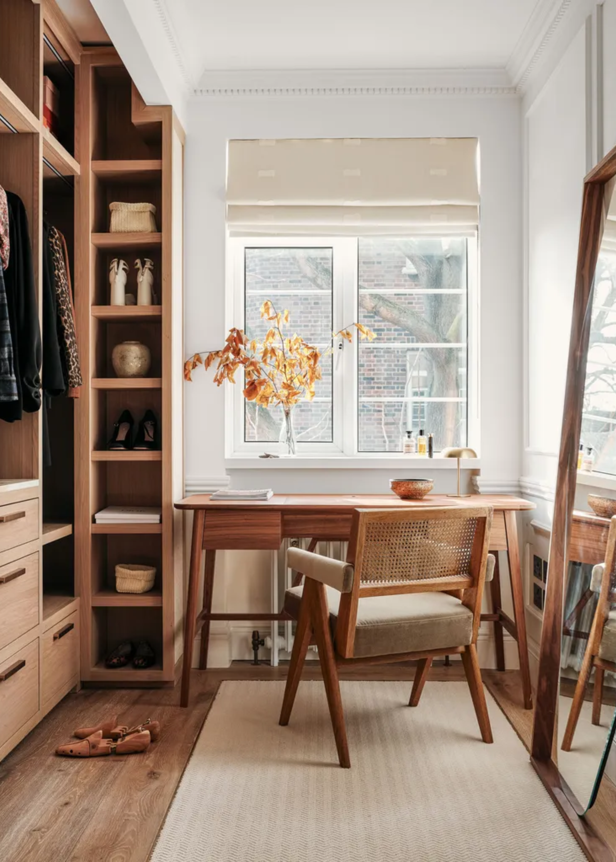 A charming dressing room with an open wardrobe, a mirror and a desk