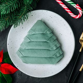 Green napkin folded into Christmas tree shape