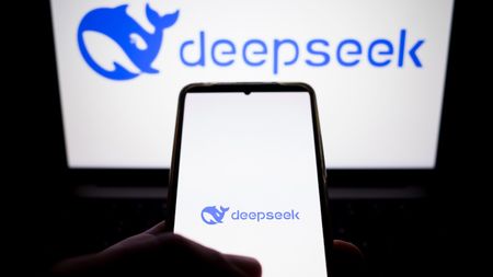 DeepSeek logo on a smartphone in front of a PC screen with the same logo.