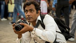 Nawazuddin Siddiqui holding a camera in the film "The Photograph"