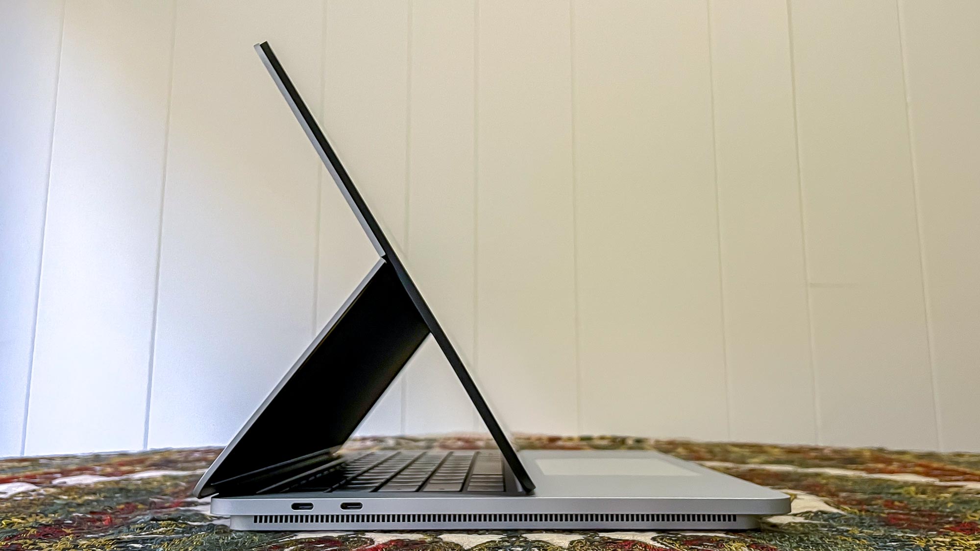 Vista lateral de Microsoft Surface Laptop Studio, pantalla en tienda sobre el teclado