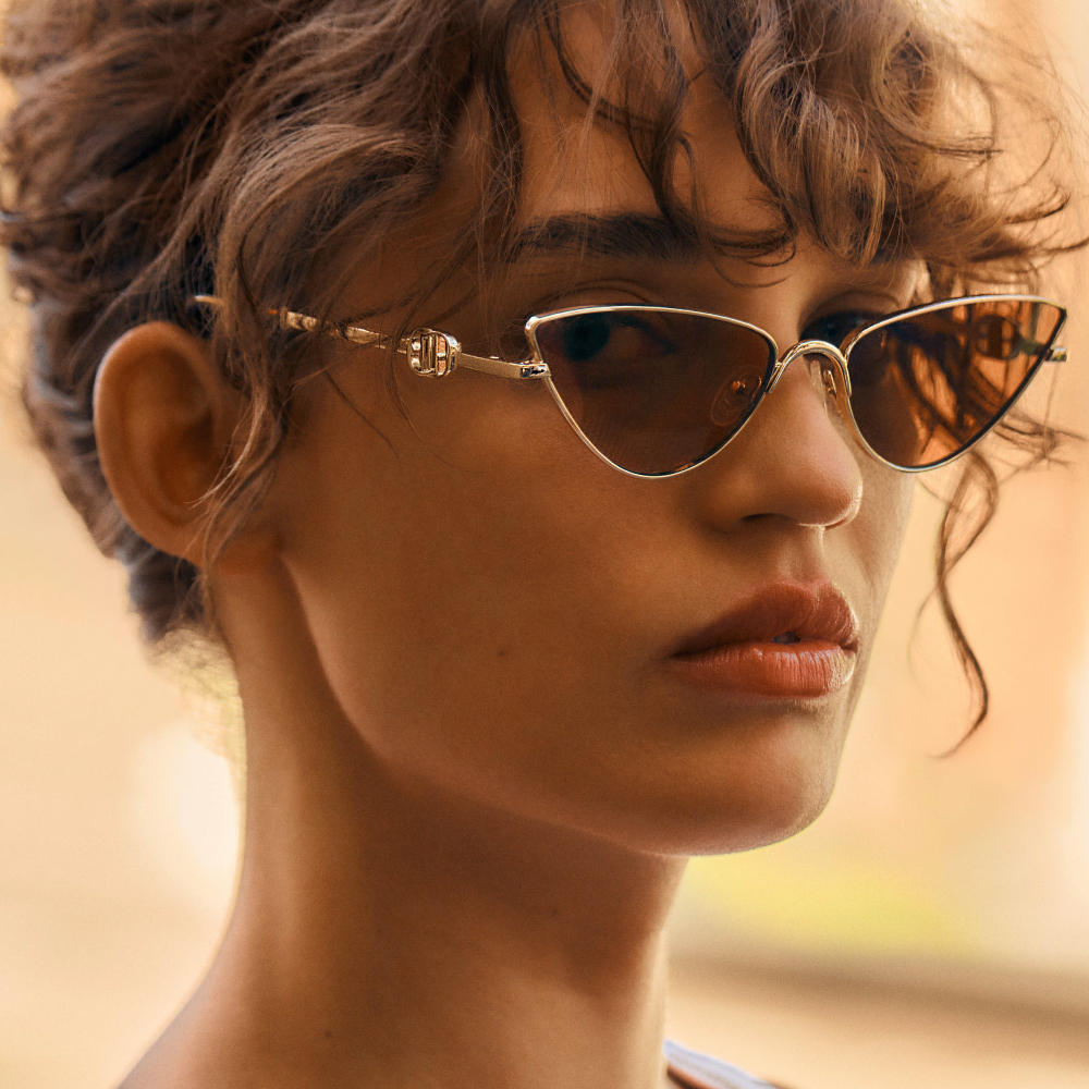 Woman wearing Le Specs sunglasses staring at camera