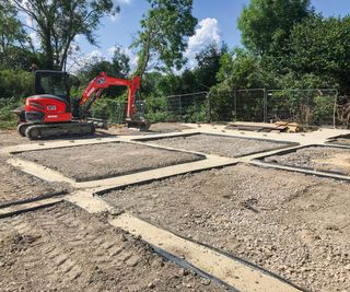 Digger being operated to level out a ground ready for a self build home to be built