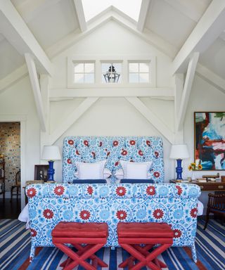 bedroom with blue and red textiles vaulted ceiling with roof lights