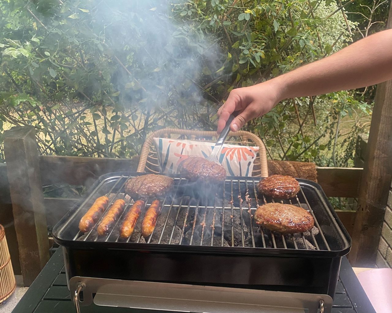 Weber Go Anywhere cooking burgers and sausages