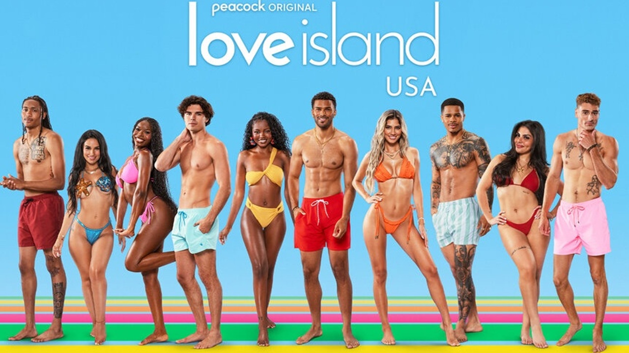 The scantily clad cast of Love Island USA Season 7 line up in front of a pastel blue background.