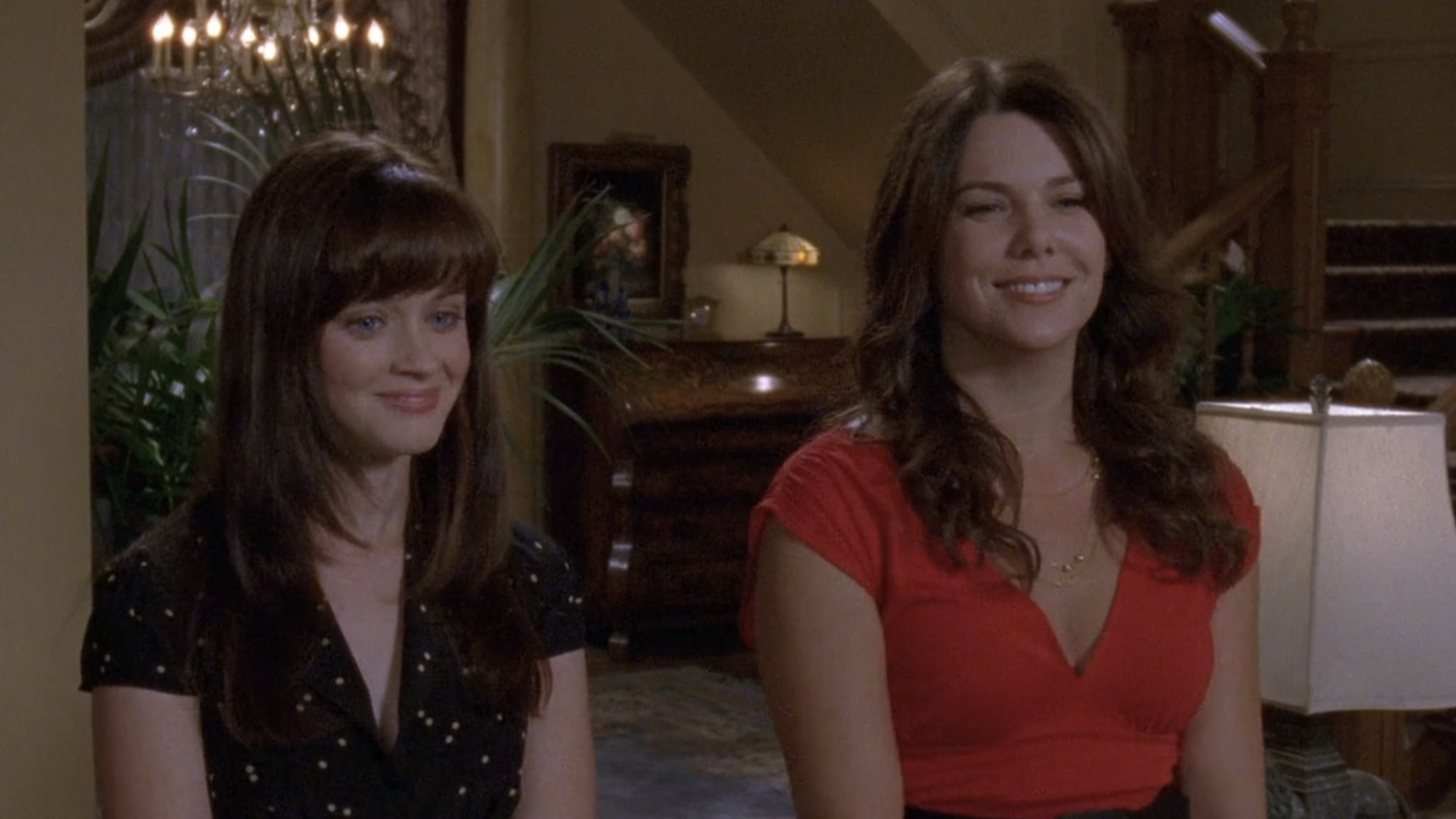 Rory and Lorelai smiling in Emily and Richard's house while meeting a young girl.