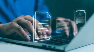 Picture of a hand typing on a laptop from the IAB website page for the new terms and conditions