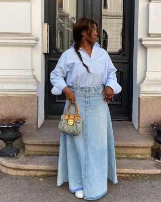 Spring trainer outfits: @nnennaechem wears a striped shirt, denim maxi skirt and white trainers