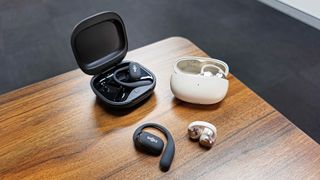 Shokz OpenFit 2 Plus and Shokz OpenDots One placed next to each other at corner of table