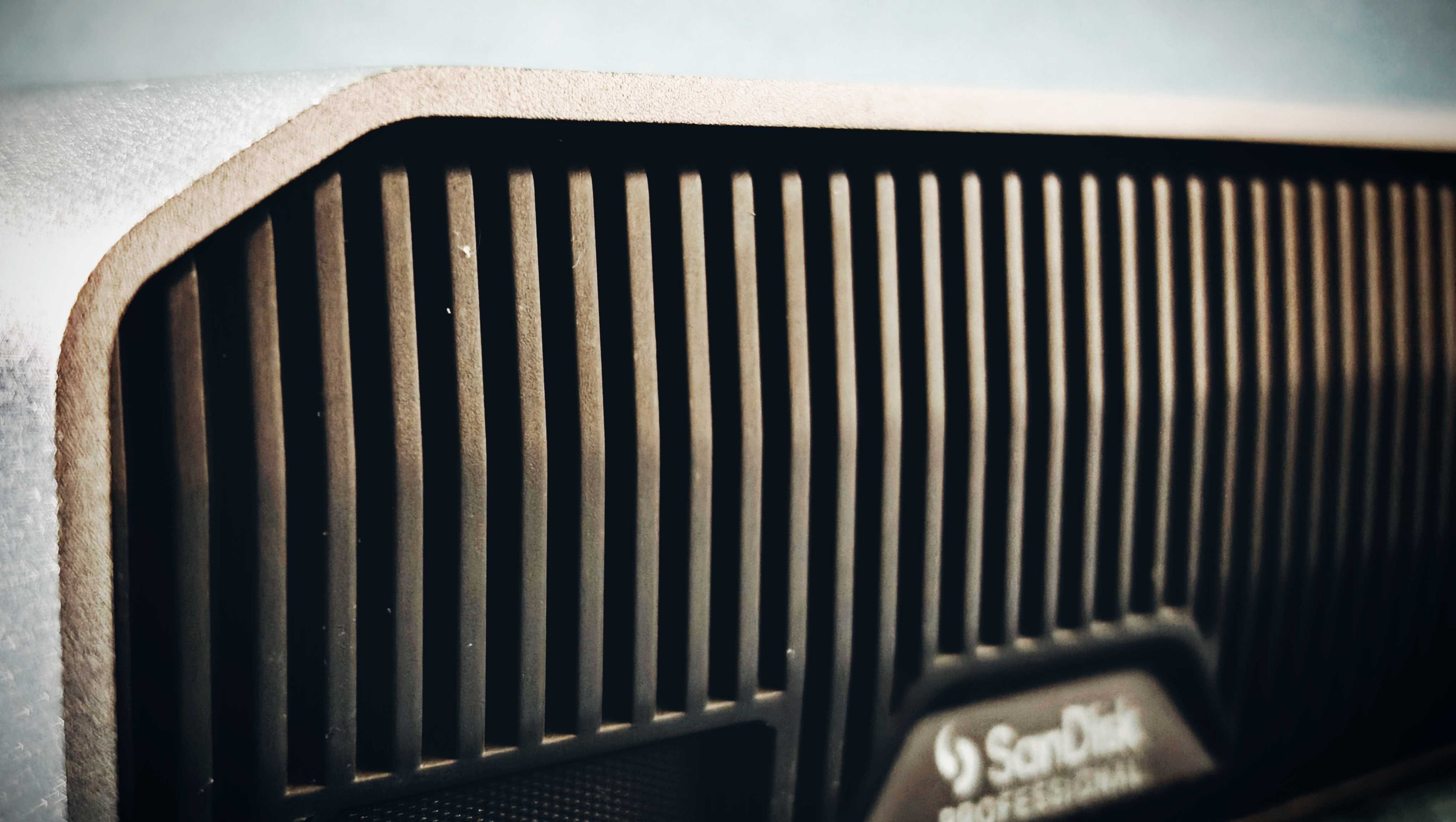 A grey and black SanDisk G-Drive sitting on a green sofa