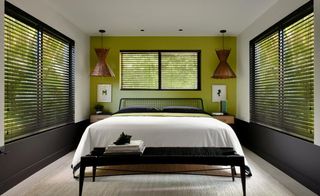 A master bedroom with a shutter on the window