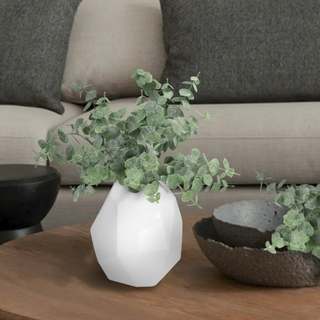 Eucalyptus stems in a white vase on a coffee table