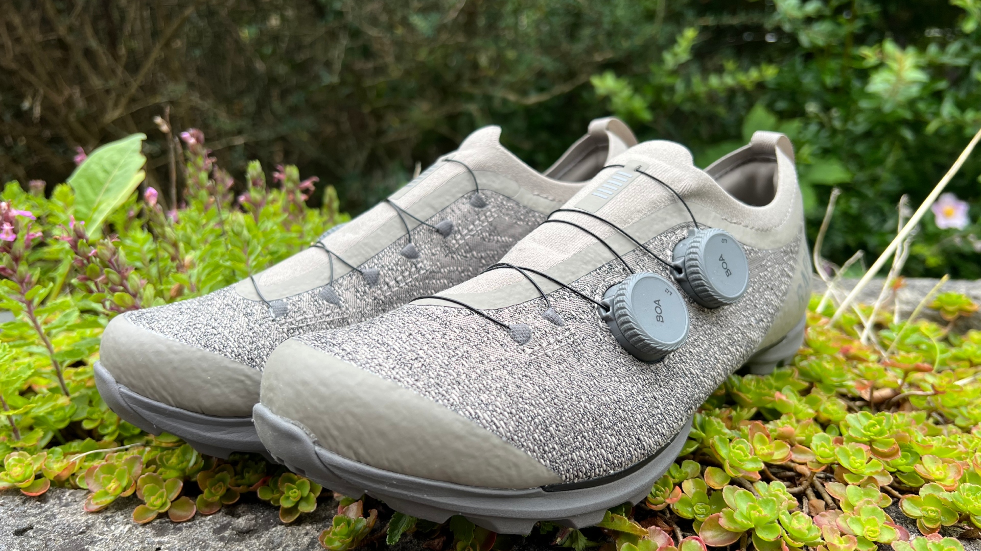 A pair of the Rapha Pro Team Powerweave gravel shoes sitting on greenary 