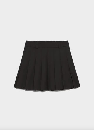 a pleated skirt in front of a plain backdrop