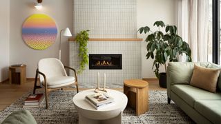σαλόνι με πλακάκια τζάκι, καρέκλα λευκής έμφασης, πολύχρωμη τέχνη, φυτά, λευκό τραπεζάκι σαλονιού