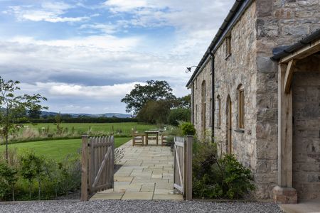 side view of restored Welsh barn with views over farmland