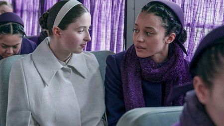 Daisy and Agnes sit next to each other on the plum bus