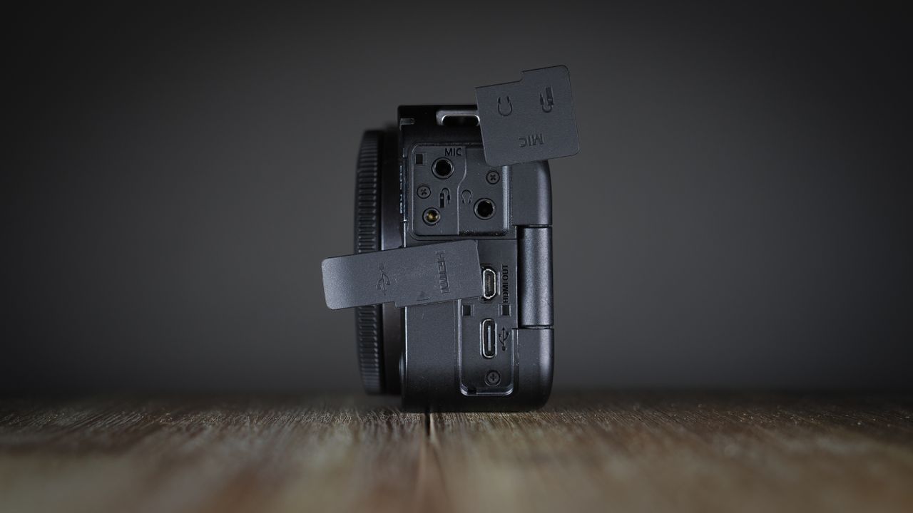 Canon EOS R50 V on a wooden surface, against a dark background