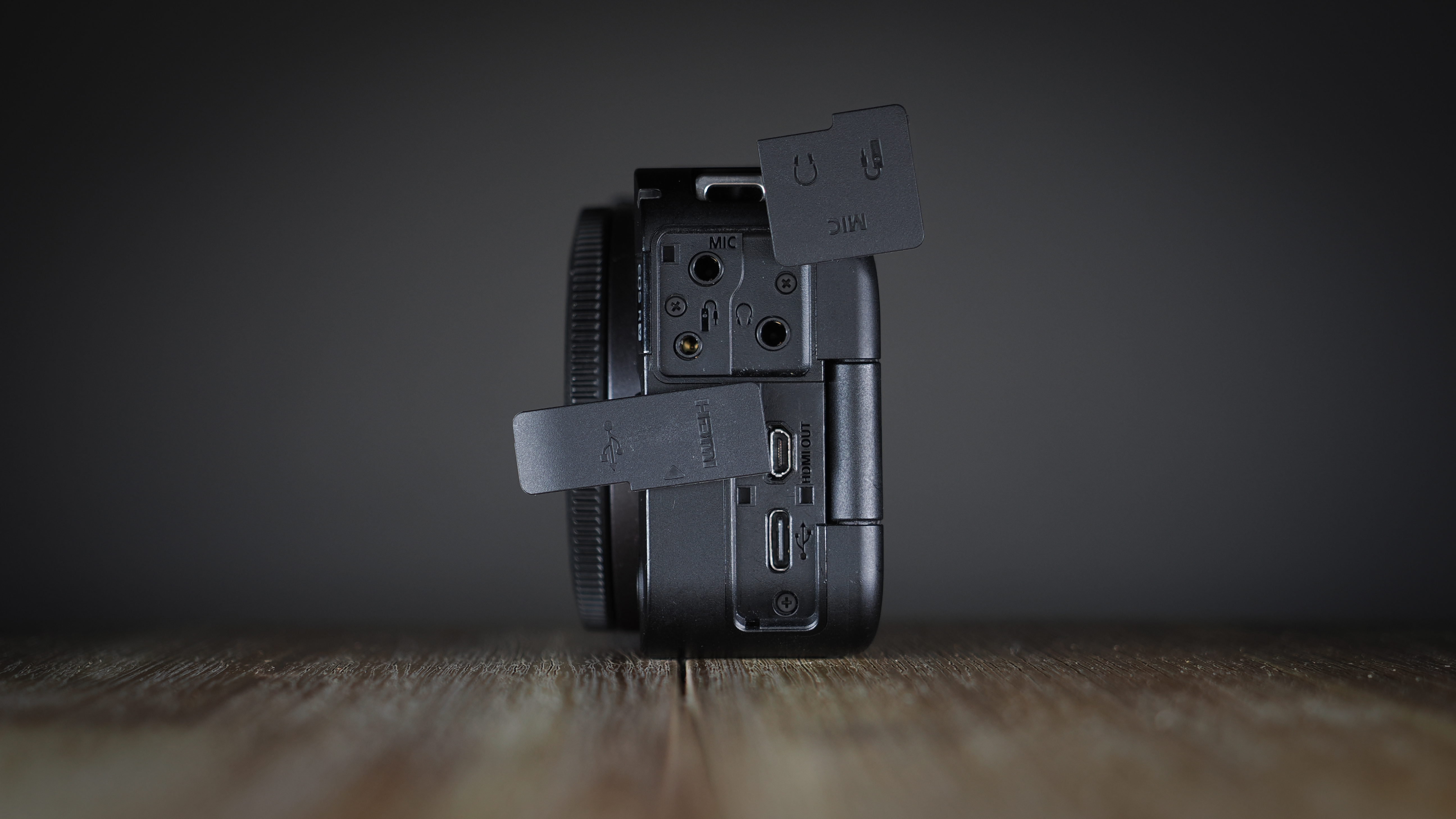 Canon EOS R50 V on a wooden surface, against a dark background