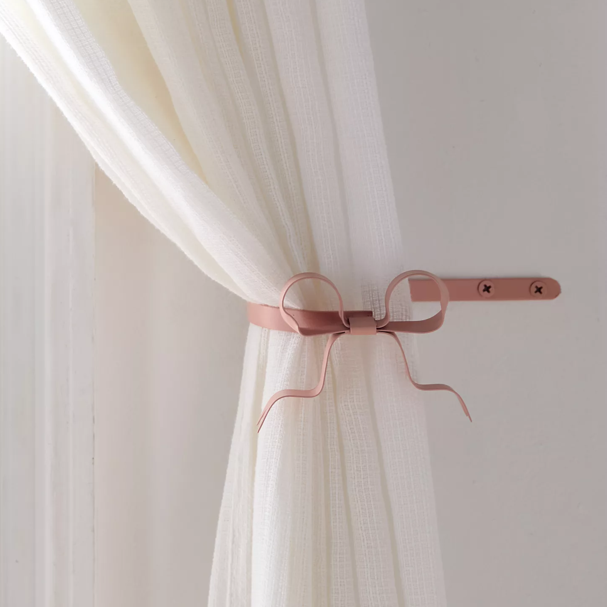 a curtain with a pink bow-shaped curtain tieback