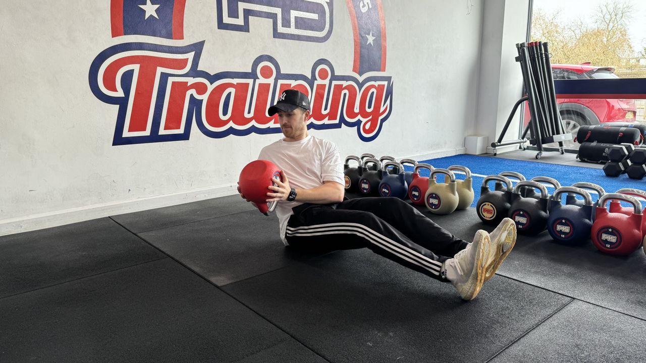 F45 personal trainer demonstrates a russian twist