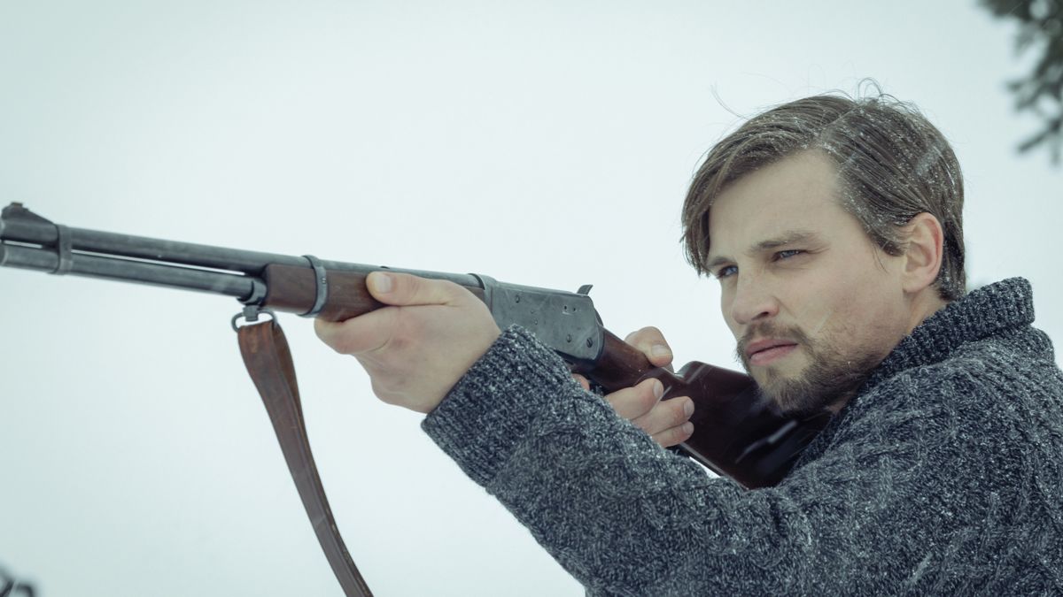 Darren Mann aiming a gun in 1923