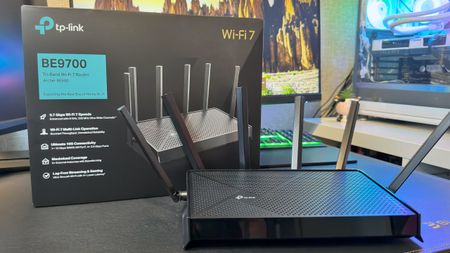 A photo of a TP-Link Archer BE9700 Wi-Fi 7 router next to its retail packaging.