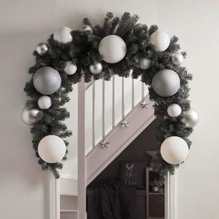 Christmas garland around doorway with large silver and white baubles