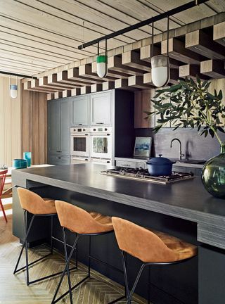 Kitchen with wood panel ceiling and island with chairs