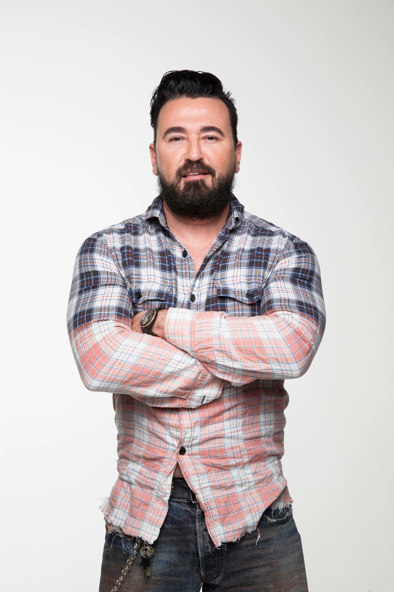 a white man with a dark beard in a plaid shirt