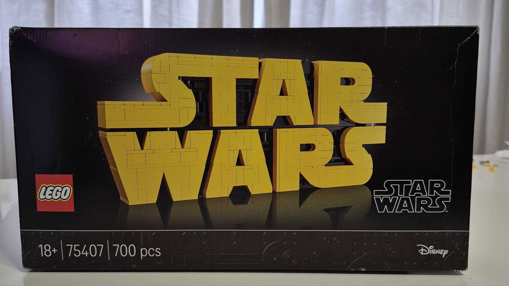 The product box of the Lego Star Wars Logo set, the Star Wars logo in brick form on a black background.