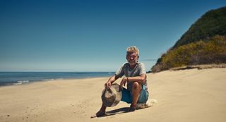 Phillip Schofield sitting on a deserted beach for Phillip Schofield Cast Away