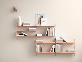wood asymmetrical modular shelves on cream colored wall, styled with books