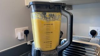 A mango and banana smoothie in a blender
