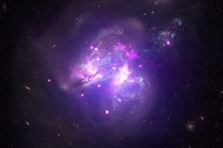 This composite image of the galactic merger Arp 299 combines X-ray data from NASA's Chandra X-ray Observatory (pink), higher-energy X-ray data from the Nuclear Spectroscopic Telescope Array, or NuSTAR (purple), and optical data from the Hubble Space Telescope (white/brown).